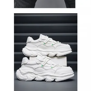 Side view of white chunky sneakers with thick melted-style soles and green accents