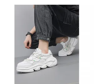 Detailed view of white leather chunky dad sneakers with thick platform soles