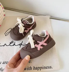 Détail de baskets d'hiver fourrées marron et rose pour enfants avec lacets blancs