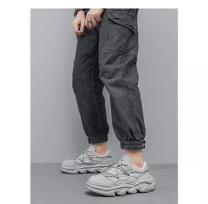 Detailed side view of grey chunky sneakers with thick wavy soles on a model