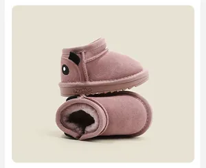 Dettaglio di stivaletti da neve neonato in camoscio rosa con fodera in peluche e maialino