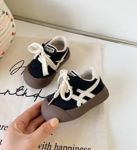 Gros plan de chaussures pour tout-petits doublées en polaire noire avec bandes blanches