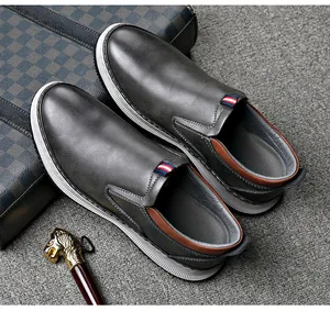 Graue Herren Slipper mit weicher weißer Sohle und braunem Fersendetail