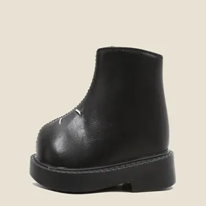 Vue détaillée de bottines Martin noires pour enfants avec semelle épaisse et surpiqûres.
