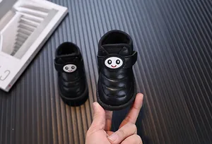Gros plan de bottes de neige noires pour tout-petits avec bande velcro abeille.