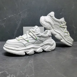 Close-up of white leather chunky sneakers with thick platform soles and rope laces.