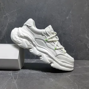 Detailed side view of white chunky sneakers with dissolving sole and leather upper