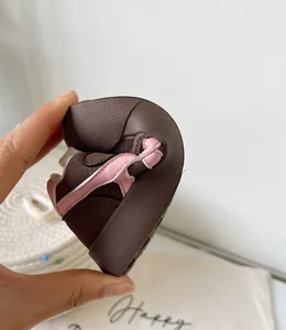Détail montrant la flexibilité des chaussures d'hiver roses et brunes pour enfants.