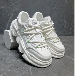 Close-up detail of white chunky dad shoes featuring platform soles and green accents