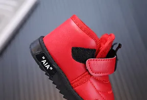 Gros plan des bottes de neige rouges pour tout-petits avec cuir et velcro