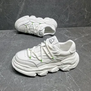 Detailed view of white leather chunky dad sneakers with dissolving soles and neon accents