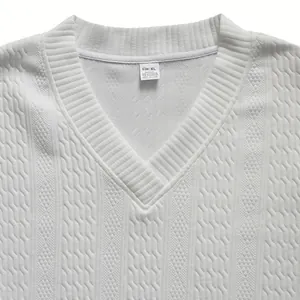 Vista de detalle de jersey de punto blanco para hombre con cuello en V y textura jacquard