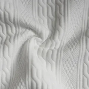 Primer plano de punto jacquard blanco con texturas de ochos y rombos detallados
