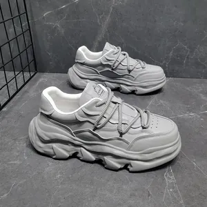 Side view of grey thick platform leather sneakers with a unique dissolving sole design