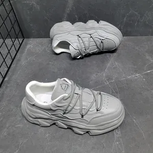 Detail view of grey leather chunky platform sneakers with a unique dissolving sole design.