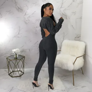 Back view of a woman wearing a sexy black ribbed backless long sleeve jumpsuit
