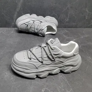 Detailed view of grey chunky sneakers with thick dissolved platform sole design
