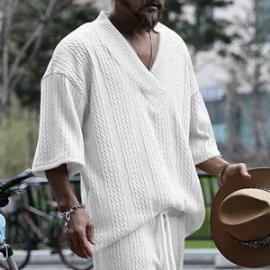 Detail van het witte kabelpatroon en de losse V-hals pasvorm van een casual heren-T-shirt