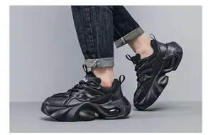 Λεπτομερής πλαϊνή όψη μαύρων chunky sneakers με χοντρή σόλα πλατφόρμας και αερόσολα