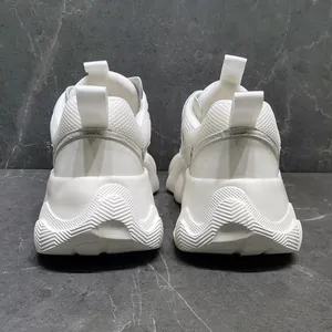 Λεπτομερής πίσω όψη λευκών sneakers με χοντρές σόλες πλατφόρμας και μοντέρνο σχέδιο