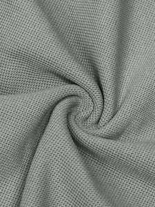 Gros plan sur la texture du tissu piqué gris respirant d'un polo pour hommes de qualité