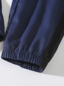 Close-up macro view of elasticated cuffs on navy blue and black patchwork cargo pants