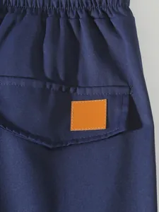 Close-up of men's navy blue cargo pants featuring elastic waist and back pocket detail.