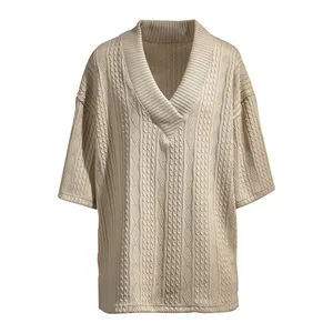 Detailweergave van beige kabelgebreide textuur op een los heren-T-shirt met V-hals
