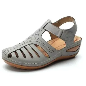 Detail of grey vintage closed-toe wedge sandals with hollow-out design for women.