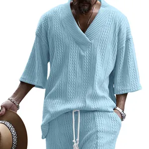 Vue détaillée de la texture tricotée bleu clair sur un t-shirt ample à col en V pour hommes