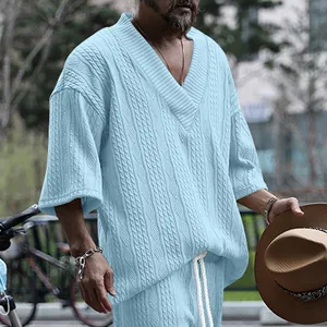 Gros plan sur la texture en maille torsadée bleue du t-shirt ample pour hommes.