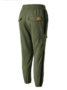 Detail view of the back of olive green cargo pants with pockets and black side stripe.