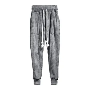 Nahaufnahme von grauen Jacquard-Strick-Joggern mit hochwertigem weißem Kordelzug-Detail
