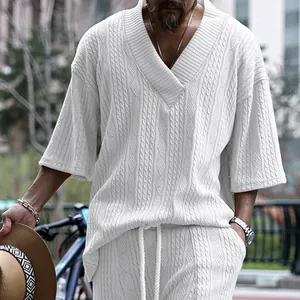 Vue détaillée de la texture tricotée torsadée blanche d'un t-shirt homme à col en V
