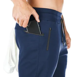 Detail of men's navy blue joggers featuring secure zippered pockets for a smartphone.