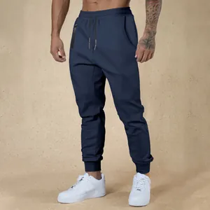 Detail view of men's navy blue joggers with drawstring waist and zip pockets