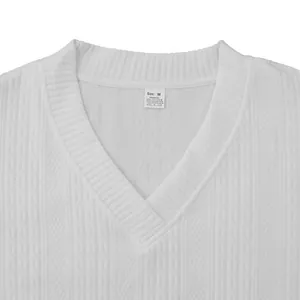 Détail d'un t-shirt tricoté à col en V blanc pour homme montrant le tissu et l'étiquette.