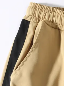 Close-up of khaki cargo pants with elastic waist and black side stripe detail