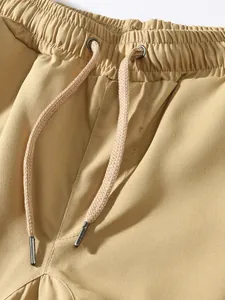 Close-up detail of men's khaki cargo pants featuring elastic waistband and drawstring.