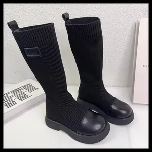 Dettaglio dei stivali a calzino neri in maglia elastica per bambini con suole spesse