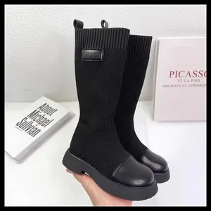 Primo piano del tessuto a maglia nero e punta liscia degli stivali a calza alti per bambine