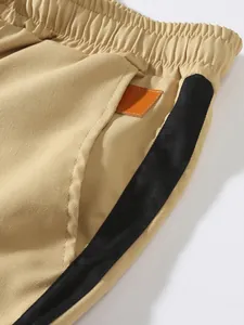 Close-up of khaki cargo pants for men featuring a side pocket and black contrast stripe