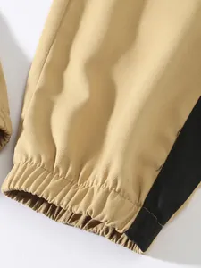 Close-up view of the elasticated cuff and durable twill fabric on khaki cargo pants.