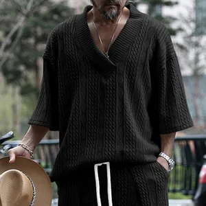 Vue détaillée d'un t-shirt pour homme en tricot torsadé à col en V de couleur gris foncé.