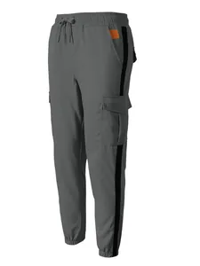 Detailed view of men's grey cargo pants with black side stripes and multi-pocket design