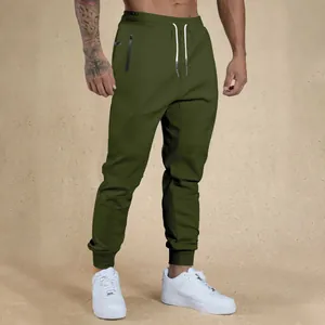 Detail of men's olive green drawstring sweatpants with zipper pocket and ribbed cuffs.