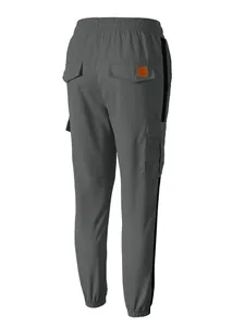 Macro view of men's grey cargo joggers with black side stripes and multi-pockets back view