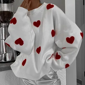 Detailansicht des übergroßen weißen Damenstrickpullovers mit leuchtend roten Herzmotiven