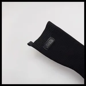 Dettaglio del polsino a coste degli stivali a calzino neri lavorati a maglia per bimba