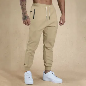 Full-length detail of men's khaki joggers with drawstring and zipper pockets